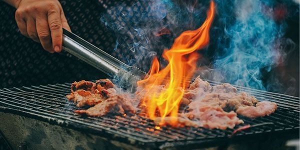 Steak brutzelt auf einem heißen Grill mit offenen Flammen