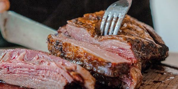 Aufgeschnittenes Steak auf einem Holzbrett, saftig und rosa in der Mitte